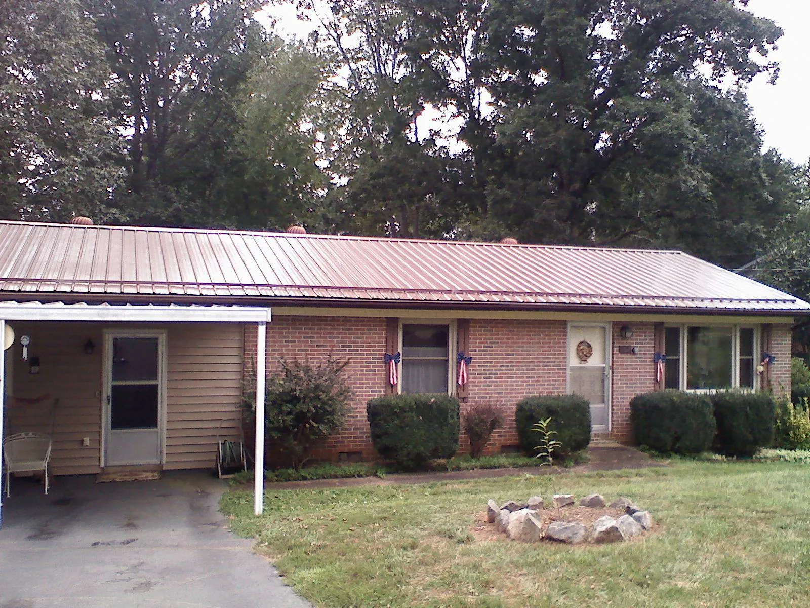 Bronze metal roof and carport on a brick ranch home — Roof Repair work by our crew in Comfort
